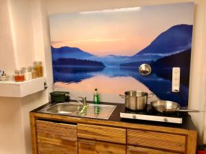 a kitchen counter with a painting of a lake at Im Herzen von Ohlstadt und am Fusse des Heimgartens in Ohlstadt