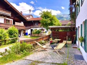 a patio with a table and chairs in a yard at Im Herzen von Ohlstadt und am Fusse des Heimgartens in Ohlstadt