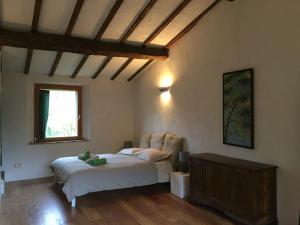 セッジャーノにあるLe Case Della Buca Agriturismo ed Agricampeggioの窓付きの部屋にベッド付きのベッドルーム1室があります。