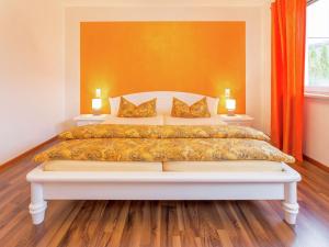a bedroom with a large bed with an orange wall at Gorgeous Apartment in Markdorf with Swimming Pool in Markdorf