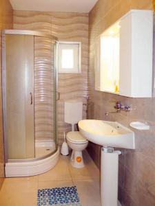 uma casa de banho com um chuveiro, um WC e um lavatório. em Natalie em Senj