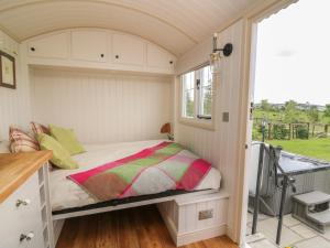un piccolo letto in una piccola stanza con finestra di Shepherd's View a Saint Harmon