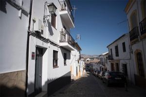 una calle con edificios y coches estacionados en la calle en Apartamento Jardines de Cuenca, en Ronda