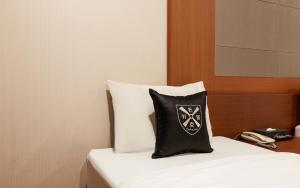 almohada blanca y negra sobre la cama en Incheon Airtel en Incheon