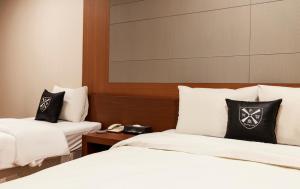 a hotel room with two beds with black and white pillows at Incheon Airtel in Incheon