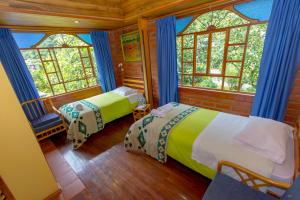 1 dormitorio con 2 camas en una habitación con ventanas en Hotel y Spa Isla de Baños, en Baños