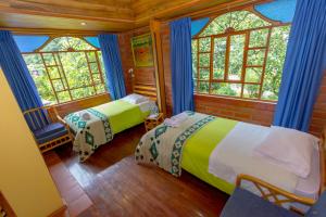 a bedroom with two beds in a room with windows at Hotel y Spa Isla de Baños in Baños