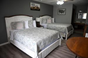 a bedroom with two beds and a table at Heidi Motel - Helen in Helen
