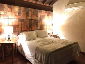 sypialnia z łóżkiem i dwoma stołami z lampkami w obiekcie Estalagem Wiesbaden w mieście Monte Verde