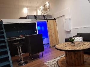 a living room with a table and a large screen tv at LH Évasion loft pour 2 avec balnéo in Le Havre