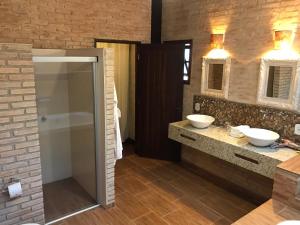 łazienka z 2 umywalkami i 2 lustrami w obiekcie Estalagem Wiesbaden w mieście Monte Verde