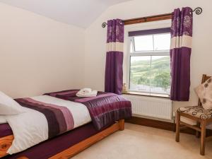 a bedroom with a bed and a window with purple curtains at Field View in Bradwell