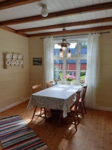 d'une salle à manger avec une table, des chaises et une fenêtre. dans l'établissement Irenegarden - Fjord view holiday home, à Lauvstad