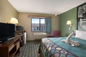 a hotel room with a bed and a television at Super 8 by Wyndham Russellville in Russellville