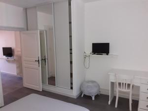 Dieses weiße Zimmer verfügt über einen Schreibtisch und einen Spiegel. in der Unterkunft Appartement PAP2S in Millau