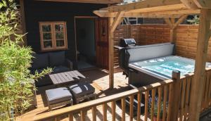 a hot tub on the deck of a house at Cheesemans Farm Stables in Manston