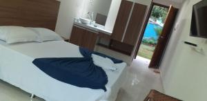 Un dormitorio con una cama con almohadas azules y una ventana en Pousada Morada Azul, en Porto de Galinhas