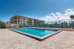 a swimming pool in front of a building at Reflections Gulf Front Condo With Ocean Views in Clearwater Beach