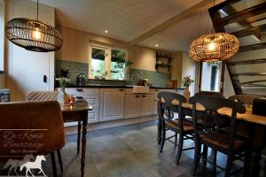 een keuken en eetkamer met een tafel en stoelen bij B&B De Konik Bourtange in Bourtange