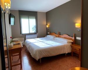 1 dormitorio con cama, mesa y ventana en Hotel Casa Custodio, en La Puebla de Roda