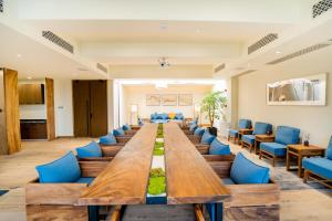 Jinling Onejoy Hotel في نانجينغ: قاعة اجتماعات كبيرة مع طاولة طويلة وكراسي زرقاء