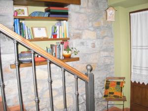 a staircase with bookshelves and a stone wall at La Llosa Rodré in Guimarán