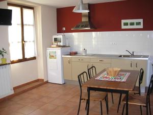 uma cozinha com uma mesa, um lavatório e um frigorífico em La Llosa Rodré em Guimarán