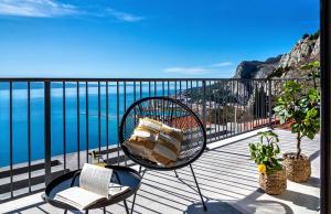 a balcony with a rattan chair and a view of the ocean at Villa The View in Omiš