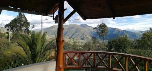 un balcón con vistas a las montañas a lo lejos en El Encanto del Taita Imbabura, en Otavalo