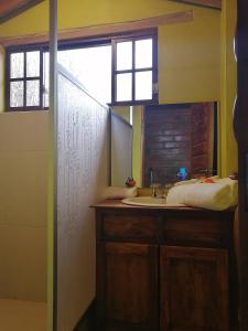 baño con lavabo y ventana en El Encanto del Taita Imbabura, en Otavalo
