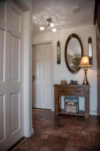 a hallway with a mirror and a table with a lamp at Drom na Gainne B&B in Carrickmore