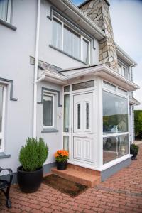 a white house with a sliding glass door at Drom na Gainne B&B in Carrickmore