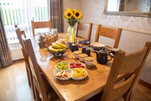 a wooden table with bowls of fruit on it at Drom na Gainne B&B in Carrickmore