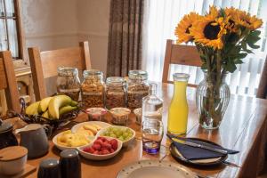 a wooden table with food and a vase of sunflowers at Drom na Gainne B&B in Carrickmore