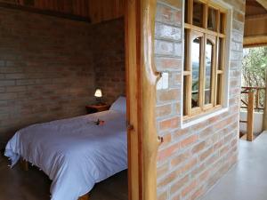 Ένα ή περισσότερα κρεβάτια σε δωμάτιο στο El Encanto del Taita Imbabura
