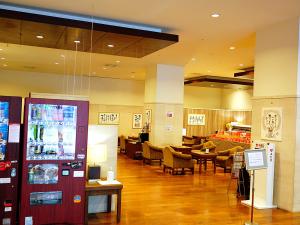 Sutton Hotel Hakata City في فوكوكا: لوبي مع مطعم به طاولات وكراسي
