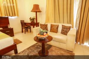 a living room with a couch and a bowl of fruit on a table at Lavendish Okrin Hotel in Kataragama