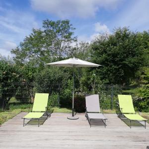 a group of lawn chairs and an umbrella at Gîte le Pech in Sainte-Foy-de-Longas