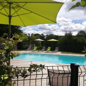 a swimming pool with chairs and umbrellas and a pool at Gîte le Pech in Sainte-Foy-de-Longas