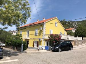 a yellow house with a car parked in front of it at Nine Sveti Juraj in Sveti Juraj