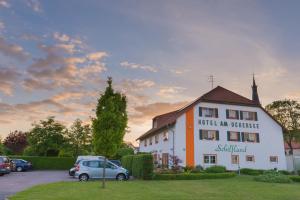 a building with a car parked in a parking lot at Hotel am Uckersee in Röpersdorf