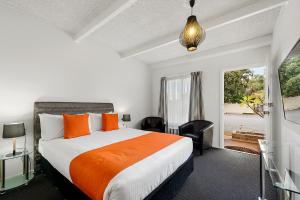 皮里港Comfort Inn Flinders on Main的一间卧室配有带橙色枕头的床和窗户。