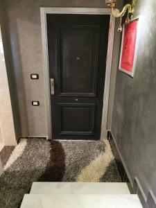 czarne drzwi w korytarzu z czarną ścianą w obiekcie Chic Apartment 2 w Szarm el-Szejk