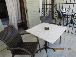 a white table with two chairs and a bowl on it at ALKMENE STUDIOS in Skiathos