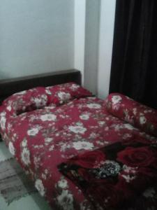 a bedroom with a red bed with a red comforter at Short stay service apartment in Dhaka