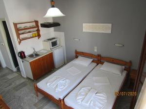 a small bedroom with a bed and a microwave at ALKMENE STUDIOS in Skiathos