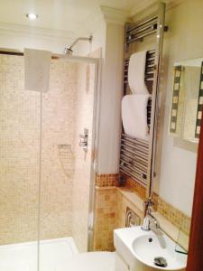 a bathroom with a shower and a toilet and a sink at The Arc - Boutique B&B in Harrogate