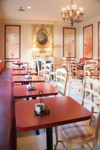 ein Restaurant mit Tischen, Stühlen und einem Kronleuchter in der Unterkunft Prince Conti Hotel in New Orleans