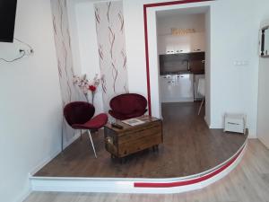 een woonkamer met 2 stoelen en een piano bij EHM Resort Mesteri in Mesteri