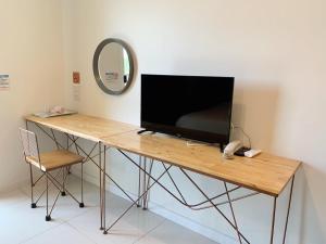 a desk with a television on top of it at iRabbit Hotel in Prachin Buri